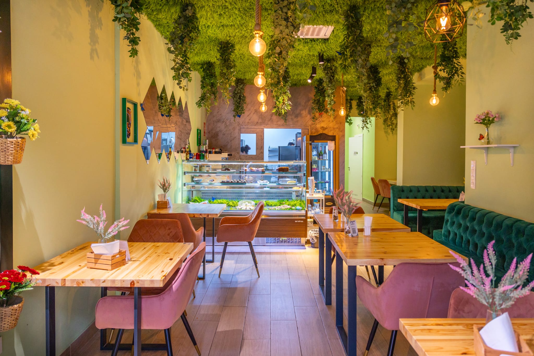 Interior of Cachitos with tables, pink chairs and hanging plants