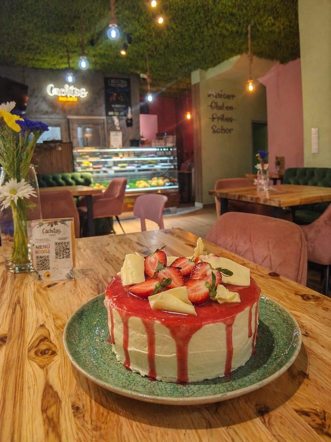 Tarta de fresas con el local de Cachitos de fondo